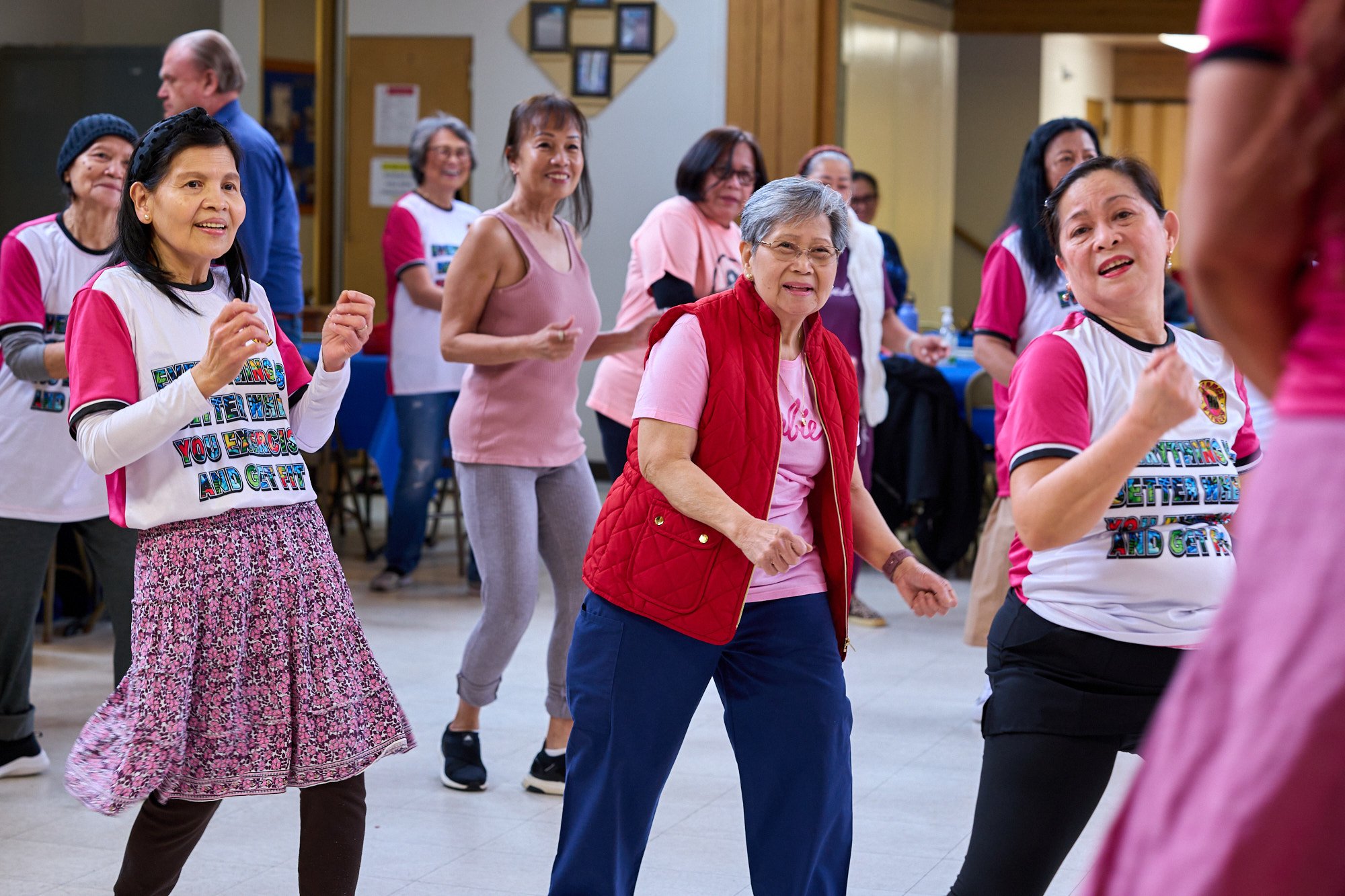a couple people dancing in a large exercise group