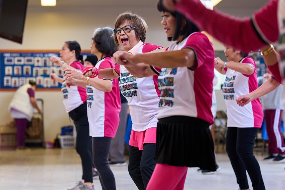 A group of older adults participating in an energetic fitness class at a community center, highlighting Sound Generations fall prevention programs for seniors and local exercise classes in Seattle.