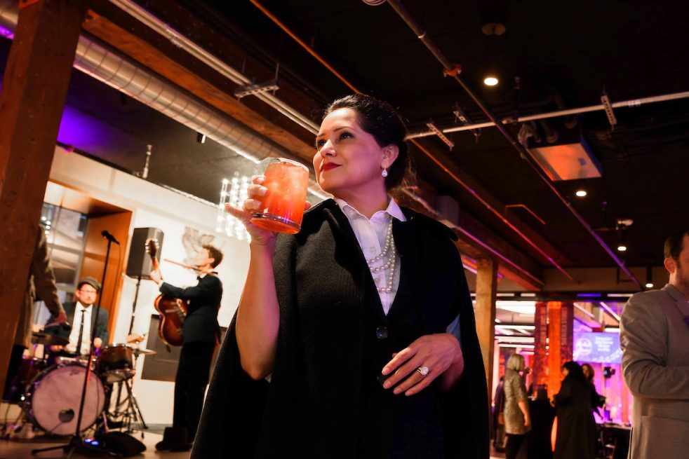 well-dressed woman holding a glass drink