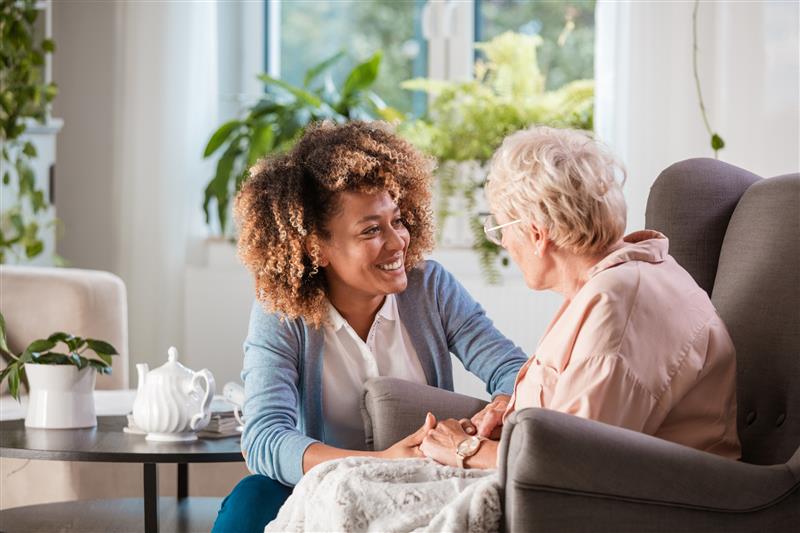 a caretaker warmly addresses an older patient
